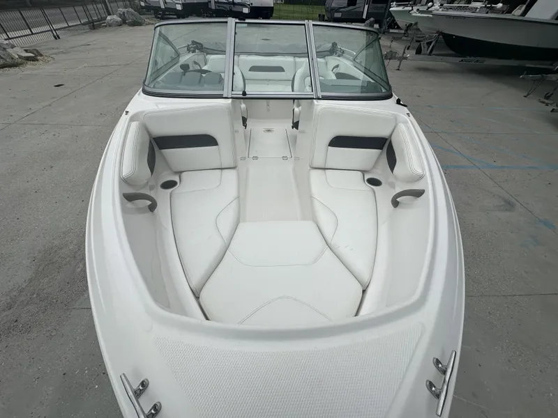 Slide: The Image of 2012 Chaparral 18 H2O Sport boat with white interior, docked on concrete. - 13