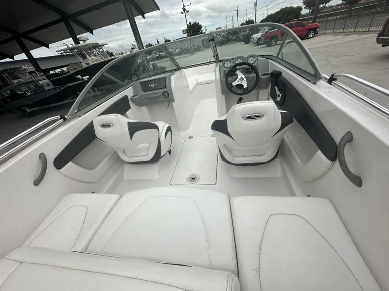 Slide: The Image of 2012 Chaparral 18 H2O Sport boat interior with white seating and steering console. - 14