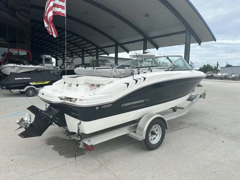 Slide: The Image of 2012 Chaparral 18 H2O Sport boat on trailer, parked outdoors under a canopy. - 2