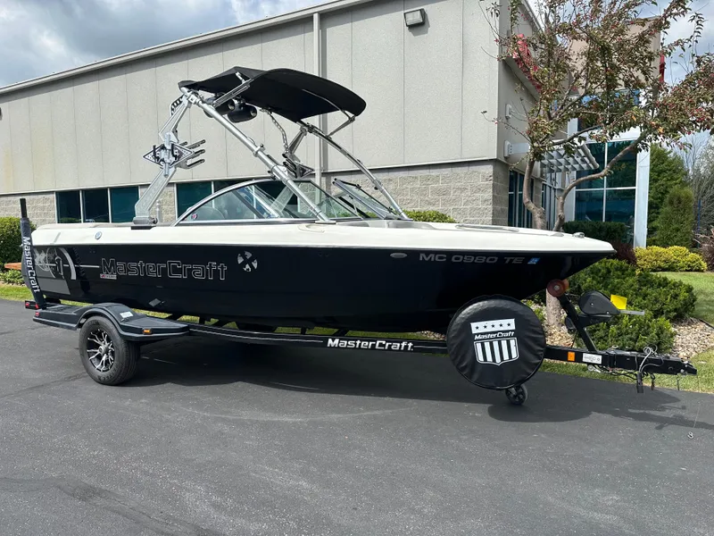 Slide: The Image of 2008 MasterCraft X-1 boat on trailer parked outside building. - 2