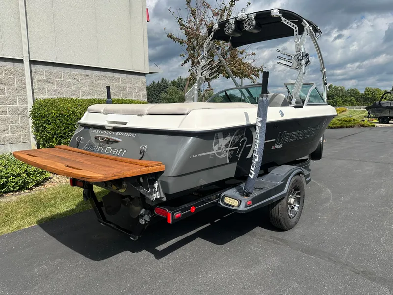 Slide: The Image of 2008 MasterCraft X-1 wakeboard boat on trailer, gray color. - 4