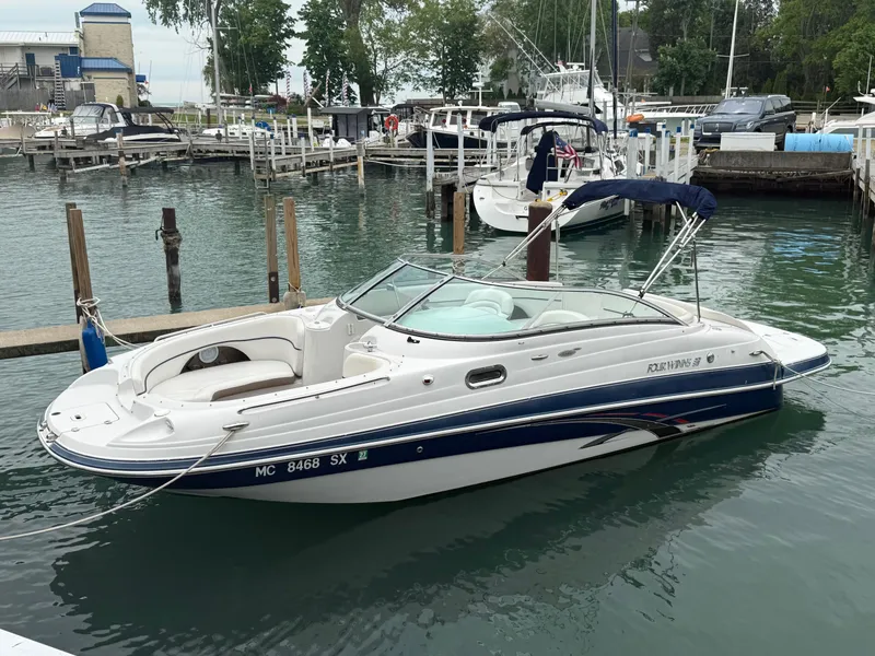 Slide: The Image of 2007 Four Winns 224 Funship boat docked in a marina, surrounded by other vessels. - 0