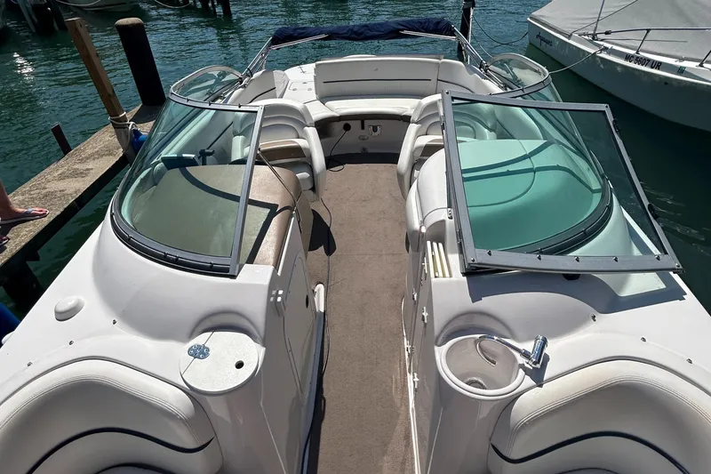 Slide: The Image of 2007 Four Winns 224 Funship boat with open seating and glass windshields on the water. - 11