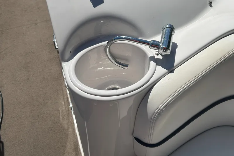 Slide: The Image of 2007 Four Winns 224 Funship boat sink with chrome faucet and white seating. - 15