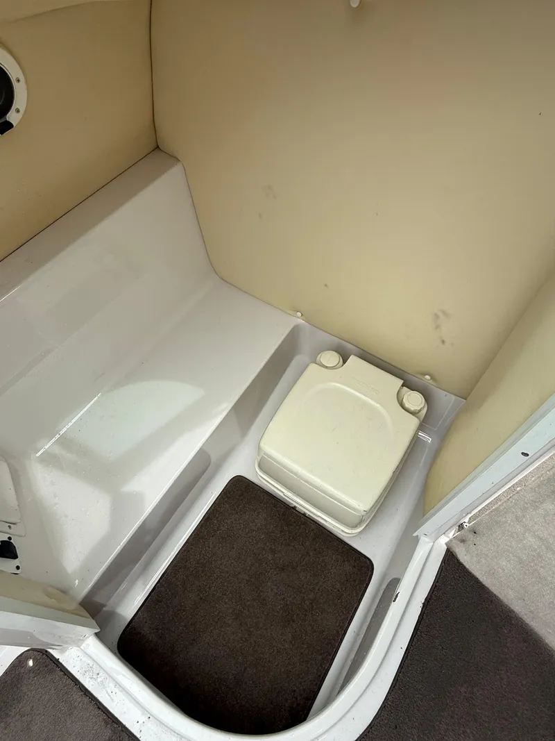 Slide: The Image of 2007 Four Winns 224 Funship boat interior with compact toilet and seating area. - 17