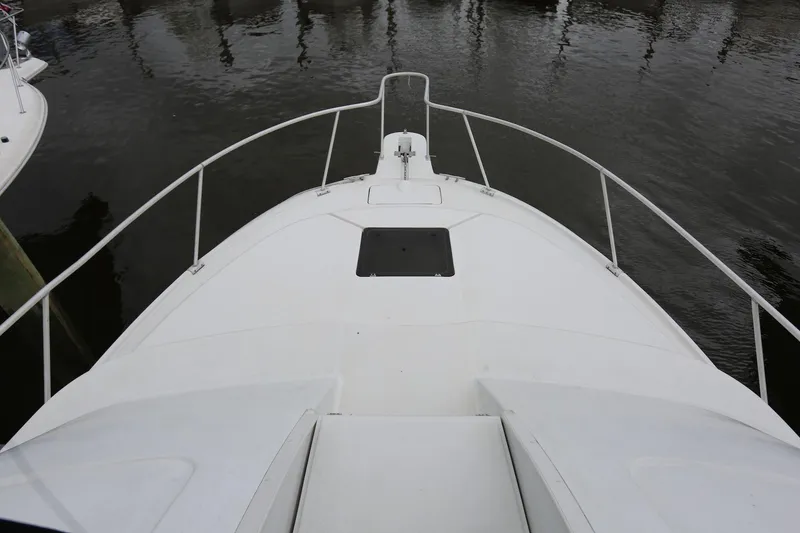 Slide: The Image of 1997 Mainship 34 Motor Yacht bow view, docked on calm water. - 20