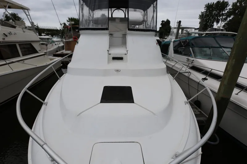 Slide: The Image of 1997 Mainship 34 Motor Yacht docked, showcasing sleek white deck and railing. - 25