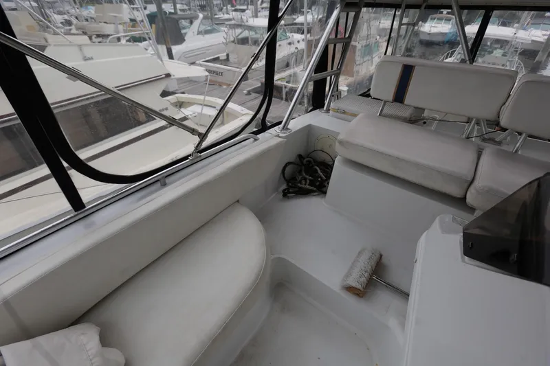 Slide: The Image of 1997 Mainship 34 Motor Yacht interior with white seating and marina view. - 40