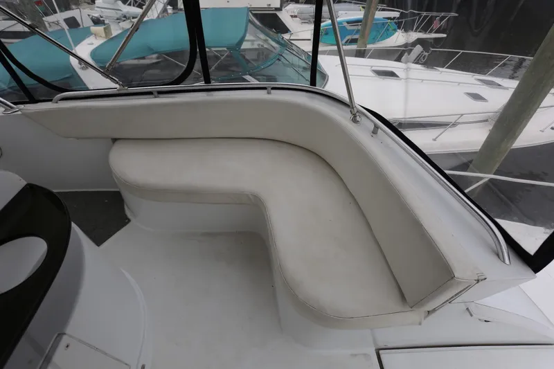 Slide: The Image of 1997 Mainship 34 Motor Yacht with curved seating on deck, surrounded by marina views. - 41