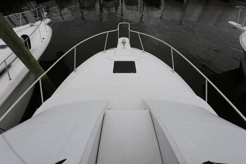 Slide: The Image of 1997 Mainship 34 Motor Yacht bow view, docked in calm waters. - 42