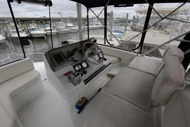 Slide: The Image of 1997 Mainship 34 Motor Yacht helm with seating, docked at marina. - 43