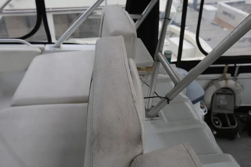 Slide: The Image of 1997 Mainship 34 Motor Yacht interior seating with visible wear and tear. - 45