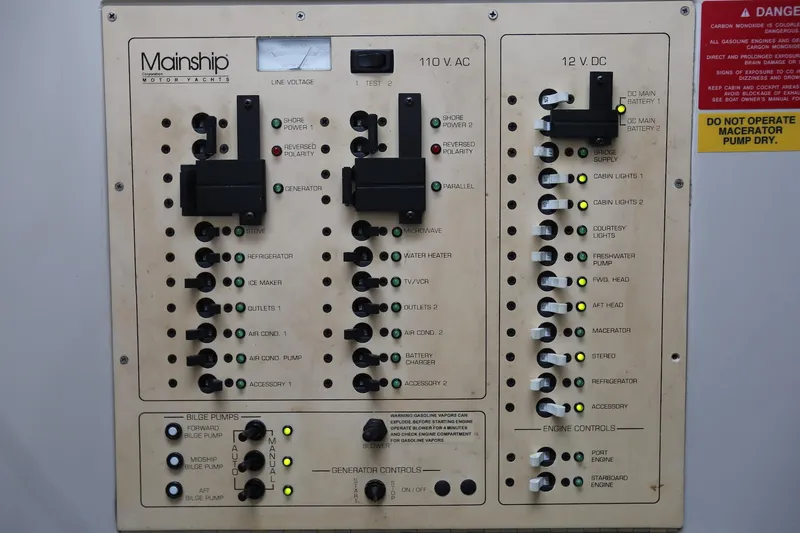 Slide: The Image of Electrical control panel of a 1997 Mainship 34 Motor Yacht, featuring 110V AC and 12V DC systems. - 49