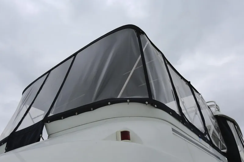 Slide: The Image of 1997 Mainship 34 Motor Yacht with clear enclosure against cloudy sky. - 8