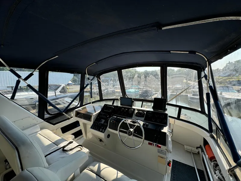 Slide: The Image of 1991 Carver 33 Aft Cabin yacht interior with helm, marina view. - 12