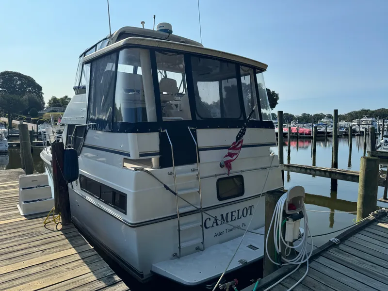 Slide: The Image of 1991 Carver 33 Aft Cabin boat docked at a marina with American flag. - 2