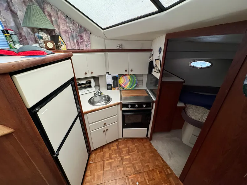 Slide: The Image of 1991 Carver 33 Aft Cabin kitchen with stove, sink, and refrigerator. Cozy and functional design. - 25