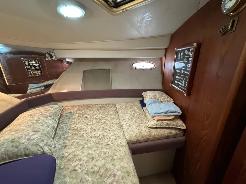 Slide: The Image of 1991 Carver 33 Aft Cabin interior with cozy bed, wood paneling, and porthole window. - 29