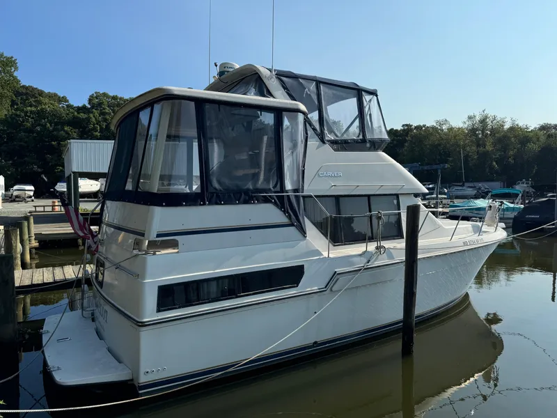 Slide: The Image of 1991 Carver 33 Aft Cabin yacht docked at marina, featuring enclosed upper deck. - 3