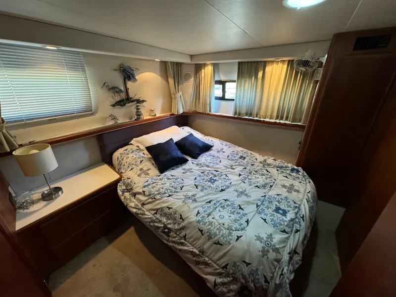 Slide: The Image of 1991 Carver 33 Aft Cabin bedroom with cozy bed, decorative pillows, and nautical decor. - 32
