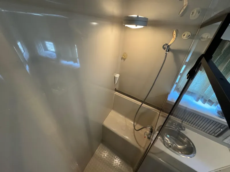 Slide: The Image of 1991 Carver 33 Aft Cabin bathroom with shower, sink, and lighting. - 36