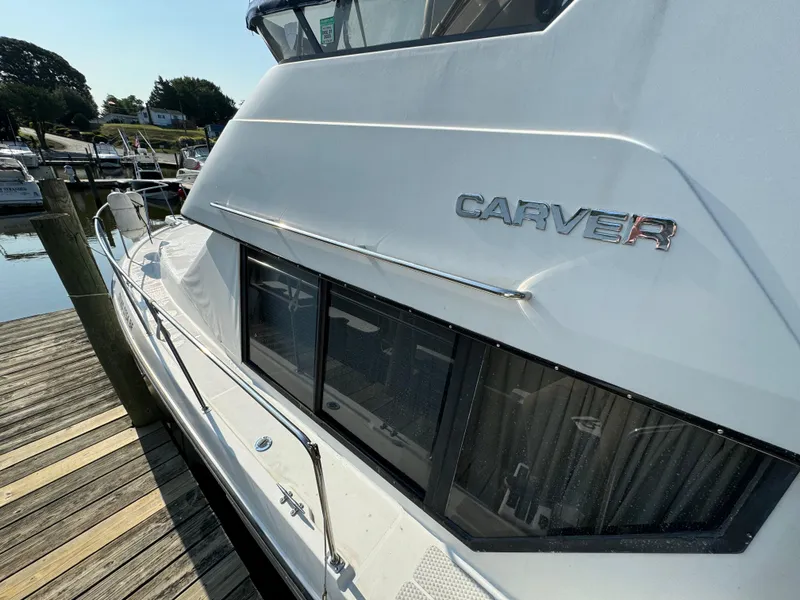 Slide: The Image of 1991 Carver 33 Aft Cabin yacht docked, showcasing sleek design and windows. - 4