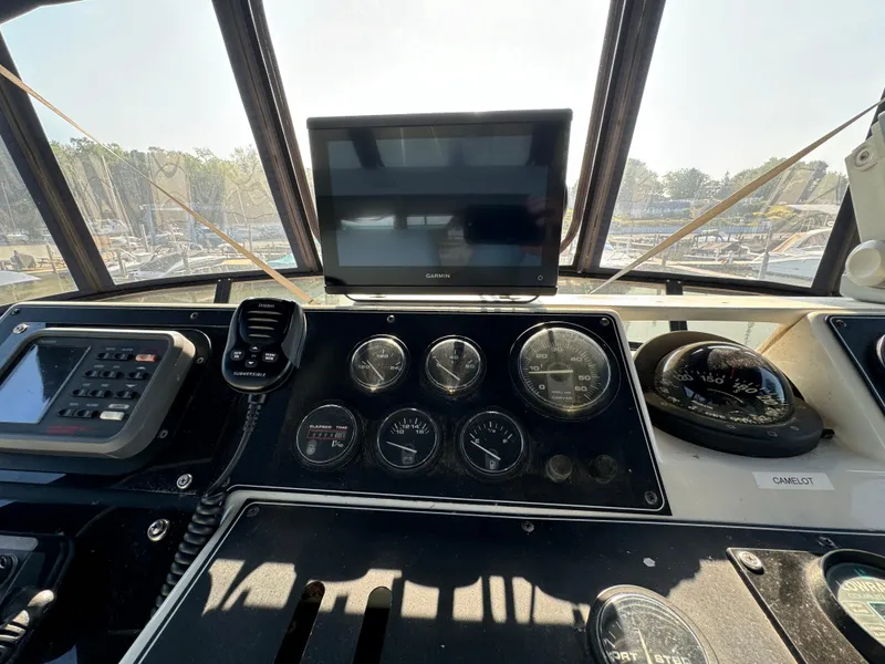 Slide: The Image of 1991 Carver 33 Aft Cabin helm with gauges, compass, and navigation equipment. - 15
