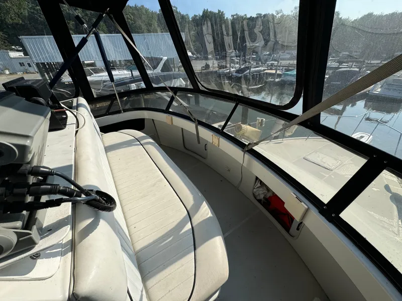 Slide: The Image of 1991 Carver 33 Aft Cabin boat interior with seating and marina view. - 18