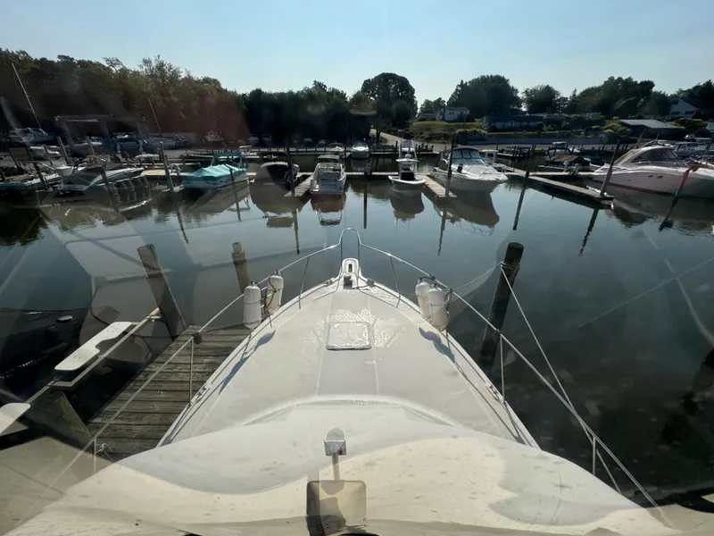Slide: The Image of 1991 Carver 33 Aft Cabin yacht docked in a serene marina setting. - 19