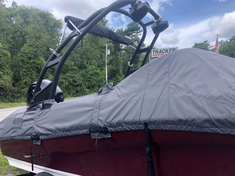 Slide: The Image of 2022 Tahoe 185 S boat with cover, parked outdoors under cloudy sky. - 2