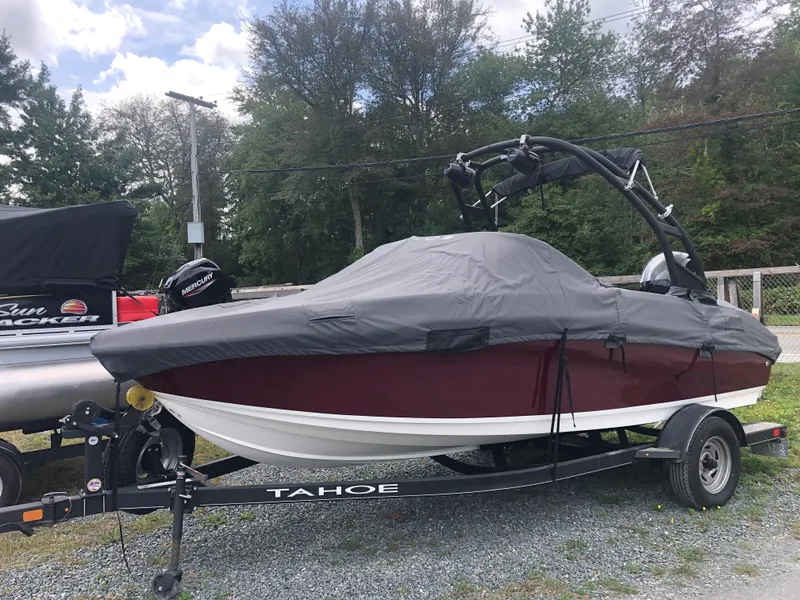 Slide: The Image of 2022 Tahoe 185 S boat covered on trailer, parked outdoors. - 5