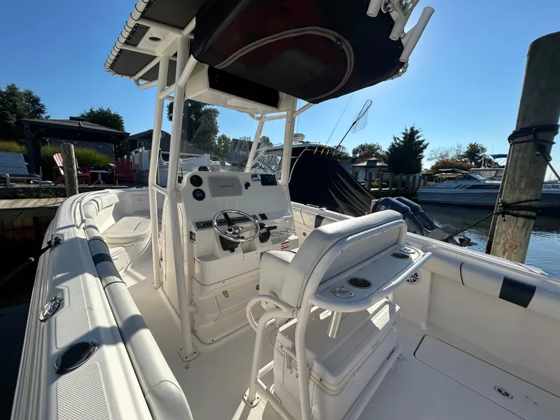 Slide: The Image of 2015 Wellcraft 252 Fisherman boat interior with steering console and seating, docked at marina. - 16