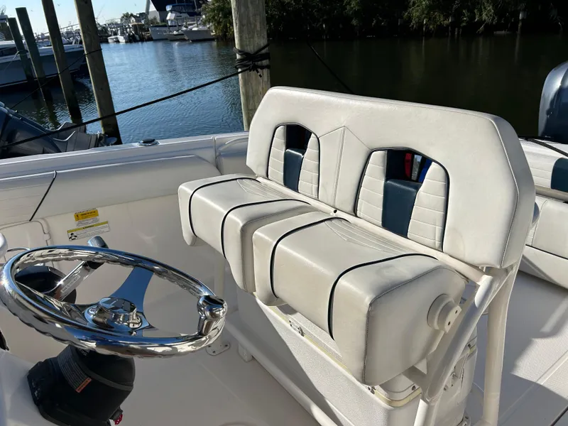 Slide: The Image of 2015 Wellcraft 252 Fisherman boat interior with steering wheel and cushioned seating. - 8