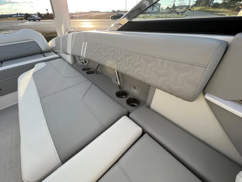 Slide: The Image of 2025 Regal LS9 boat interior with gray and white seating, cup holders, and speaker. - 9