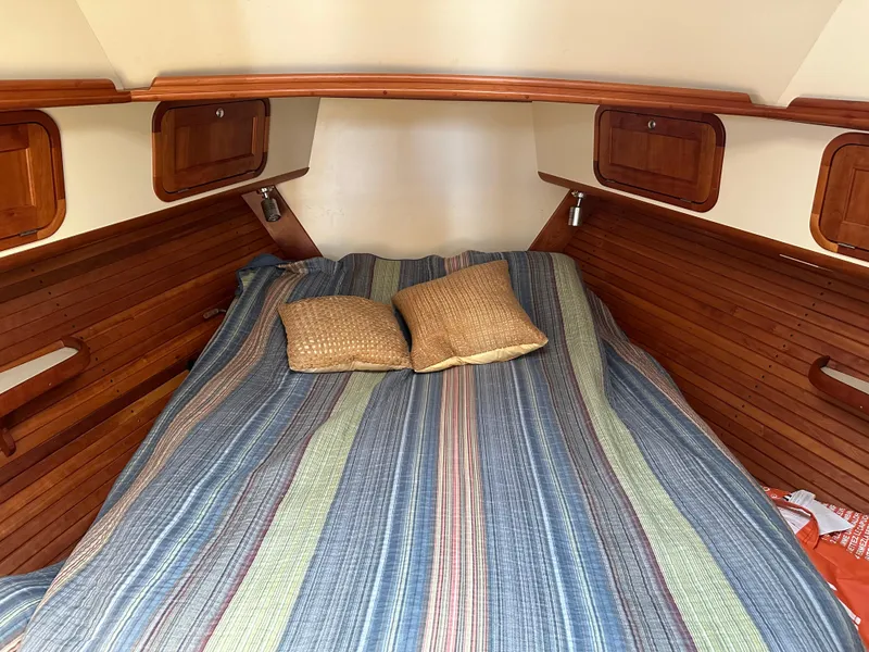 Slide: The Image of Cozy cabin interior of 2005 Legacy 42 boat with striped bedding and wooden accents. - 13