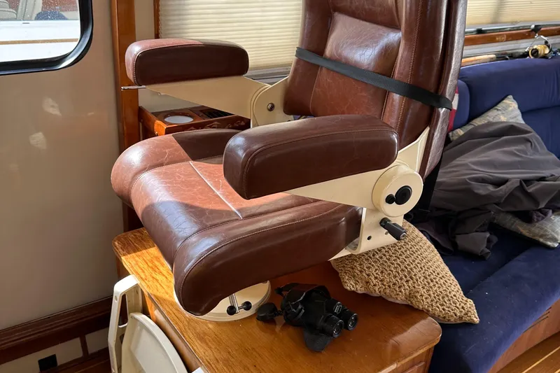 Slide: The Image of Brown leather chair inside a 2005 Legacy 42 boat cabin, with a wooden table. - 16