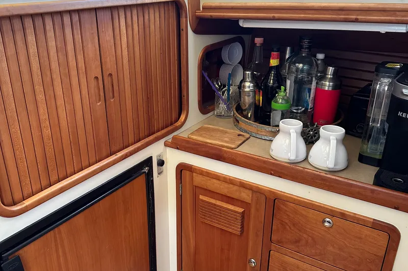 Slide: The Image of Wooden boat galley with cabinets, drinkware, and appliances on a Legacy 42, 2005 model. - 17