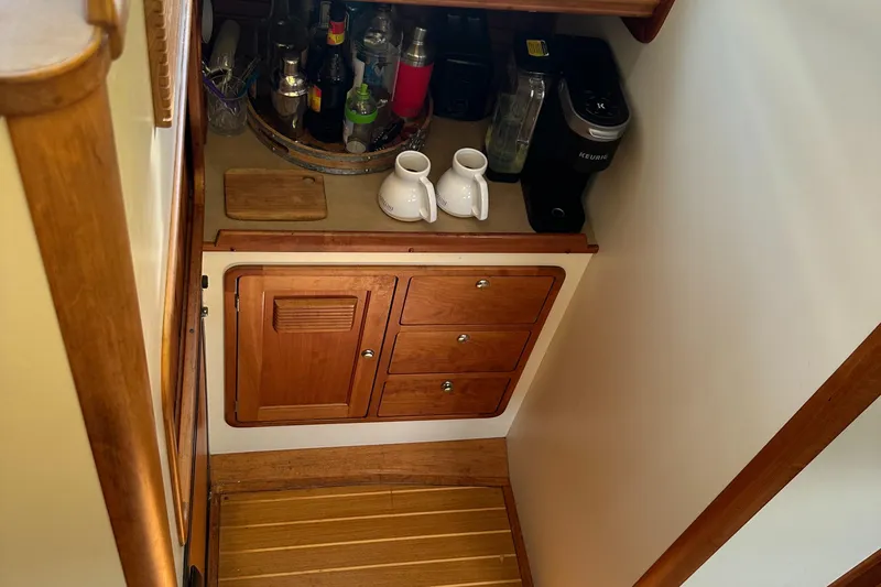 Slide: The Image of Compact galley area in 2005 Legacy 42 boat with wooden cabinetry and countertop appliances. - 18