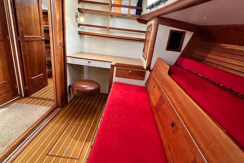 Slide: The Image of Interior of 2005 Legacy 42 boat with red seating and wooden accents. - 19