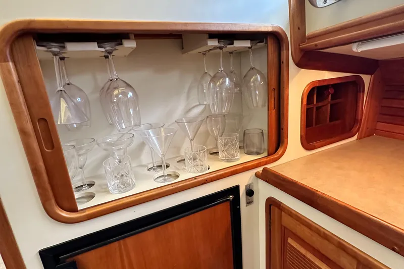 Slide: The Image of Glassware storage in a 2005 Legacy 42 yacht interior, featuring wine and cocktail glasses. - 21