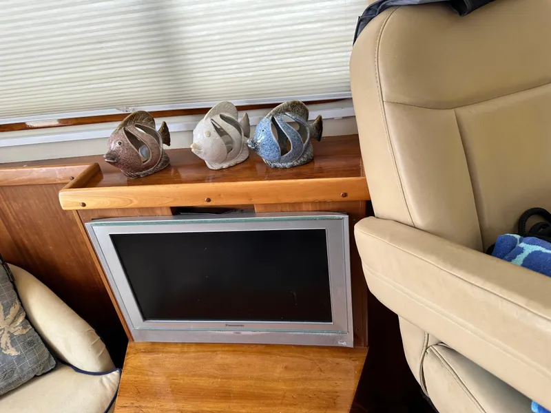 Slide: The Image of Interior of 2005 Legacy 42 with TV, fish sculptures, and beige seating. - 23