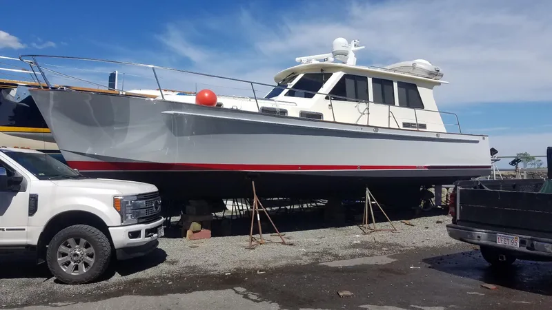 Slide: The Image of 2005 Legacy 42 boat on dry dock, with trucks nearby under a clear blue sky. - 3