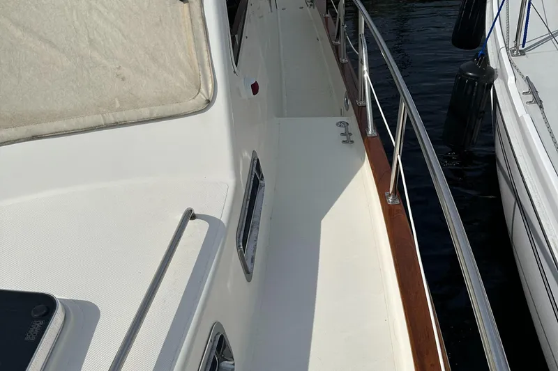 Slide: The Image of 2005 Legacy 42 yacht deck with railing and docked beside another boat. - 7