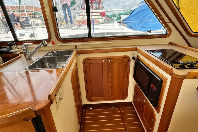 Slide: The Image of Legacy 42 yacht kitchen interior with wooden cabinets, sink, and appliances, 2005 model. - 9