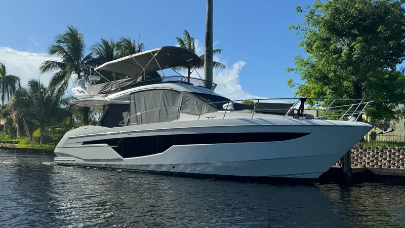 The Image of 2019 Galeon 500 Fly yacht docked by palm trees and water. - 0
