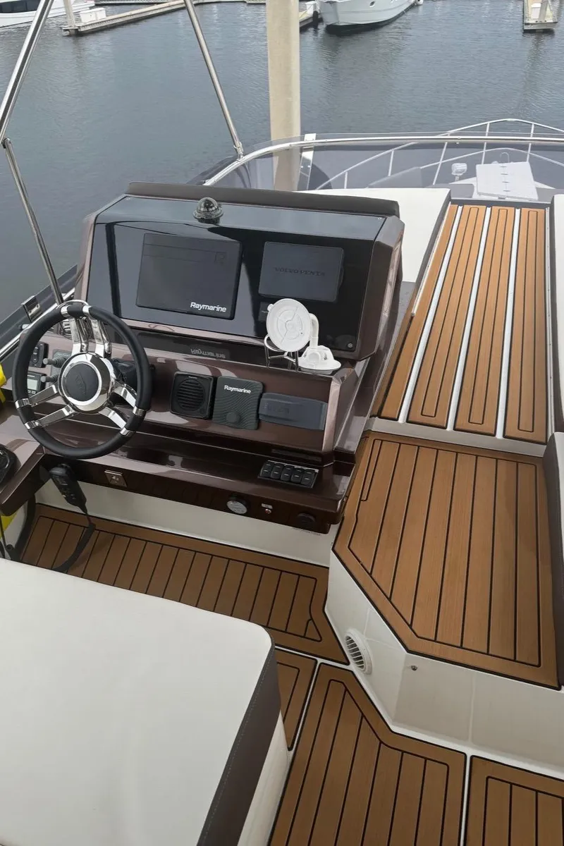 Slide: The Image of 2019 Galeon 500 Fly yacht helm with modern controls and wood finish. - 12