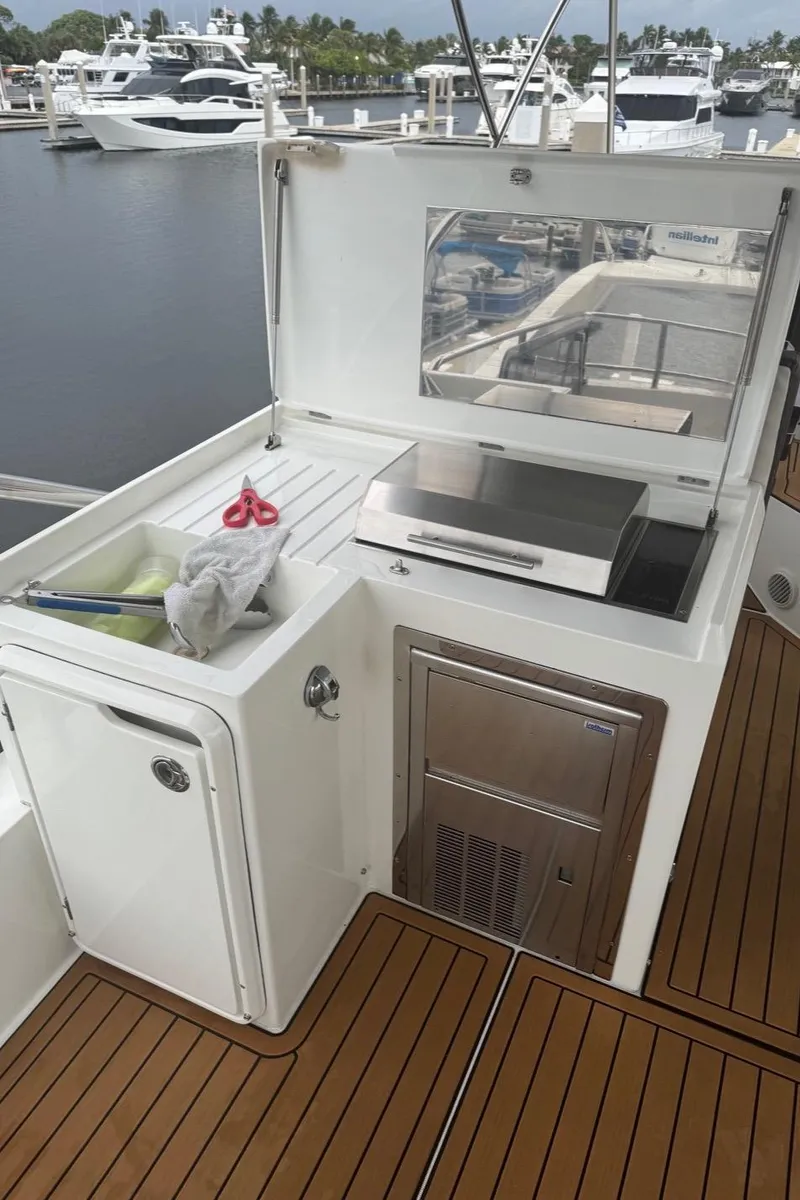 Slide: The Image of Galeon 500 Fly 2019 yacht outdoor kitchen with grill and storage, docked at marina. - 15