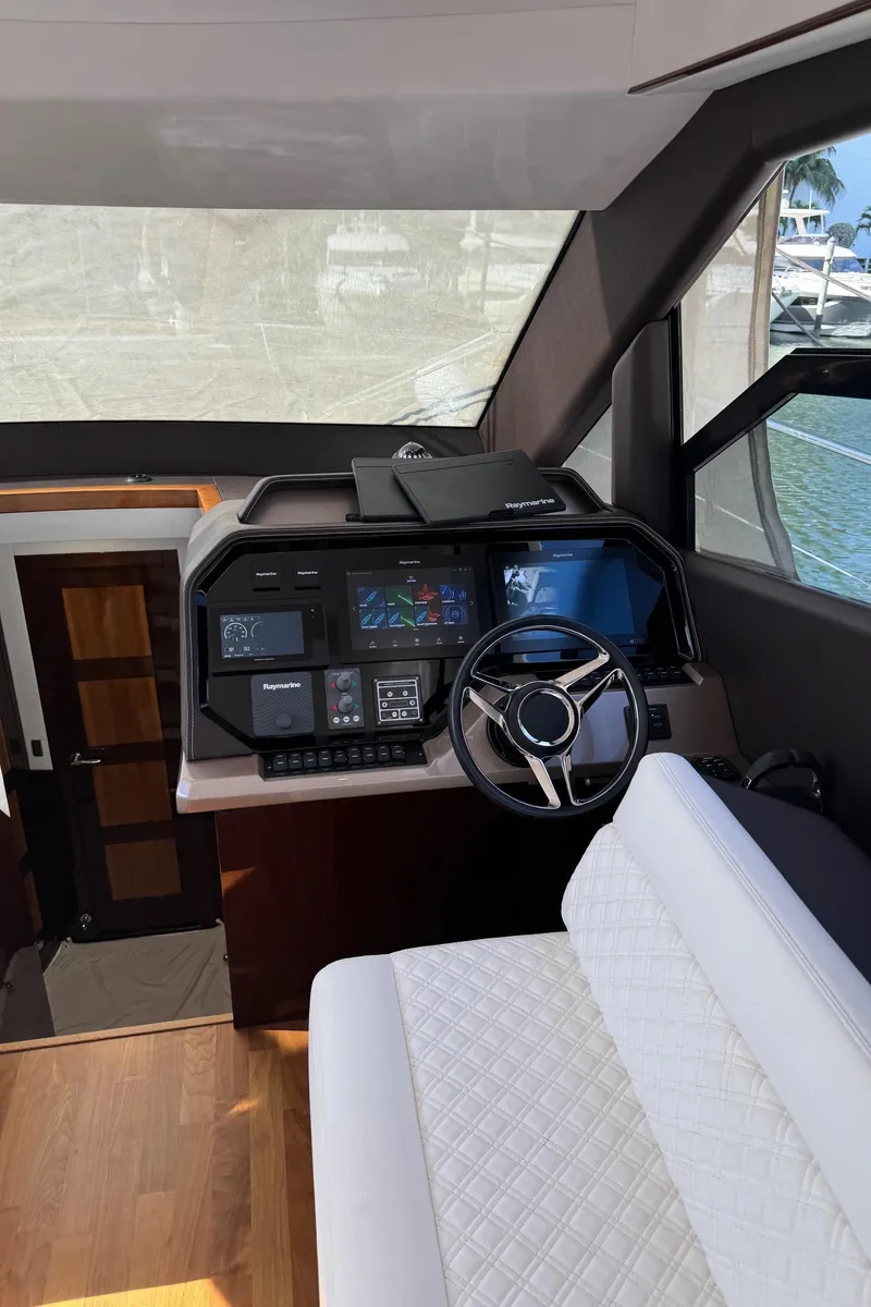 Slide: The Image of 2019 Galeon 500 Fly yacht helm with modern controls and plush seating. - 22