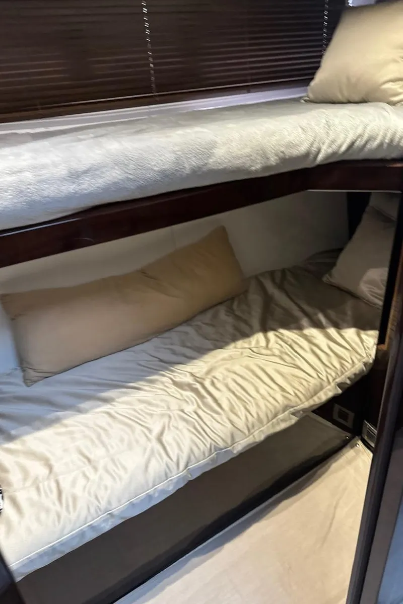 Slide: The Image of Bunk beds in 2019 Galeon 500 Fly yacht cabin, featuring cozy bedding and wooden accents. - 31