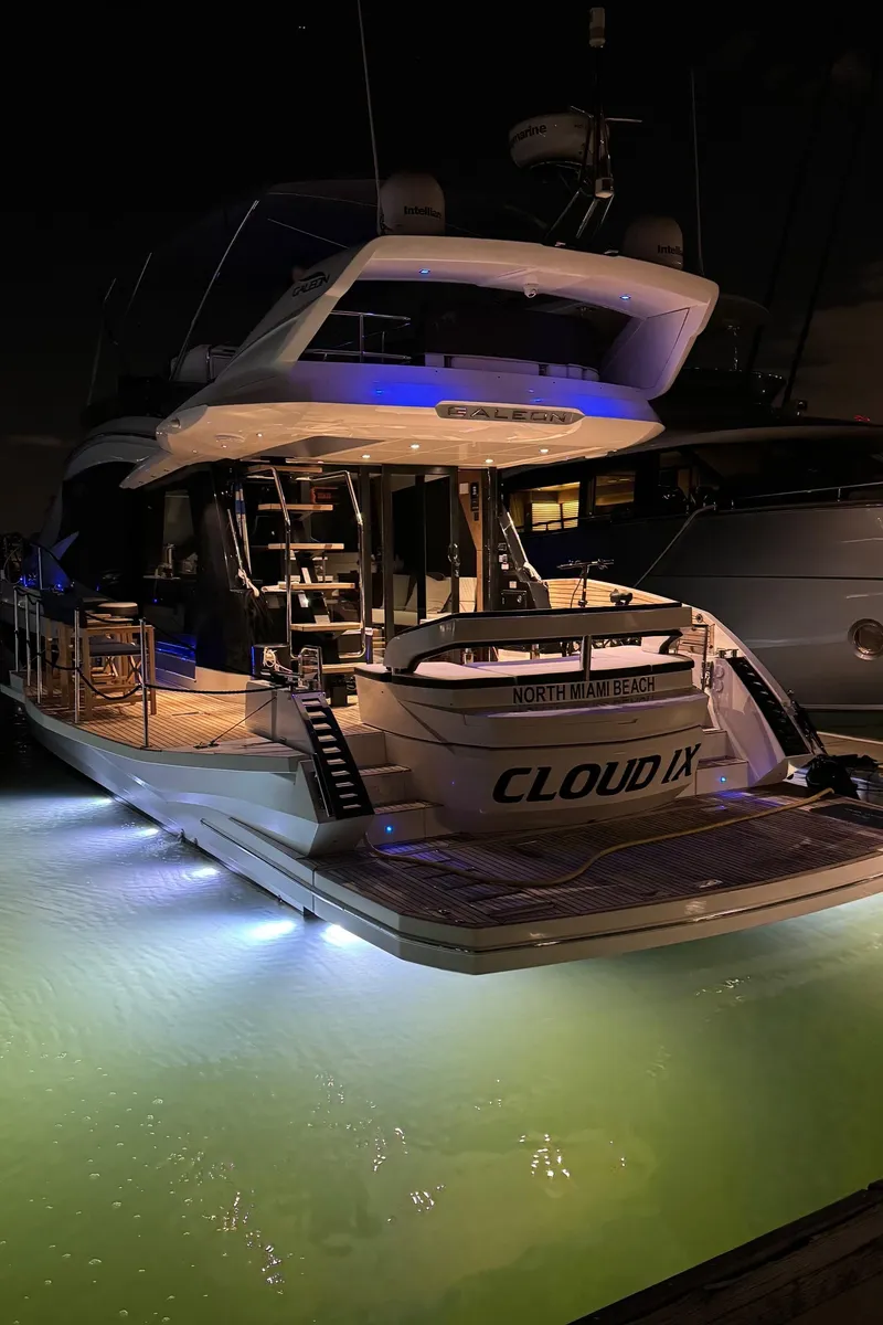 Slide: The Image of 2019 Galeon 500 Fly yacht illuminated at night, docked with glowing underwater lights. - 4